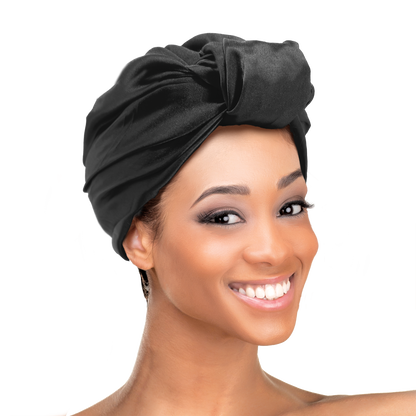 Woman wearing the Qfitt Doobie Cap With Silky Scarf, a hair wrap cap with an attached scarf.